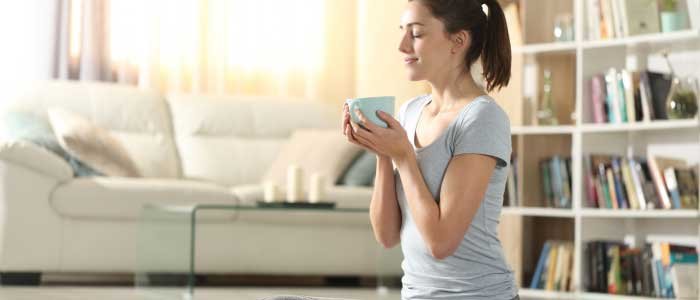 girl holding a cup of matcha while meditating to find her zen