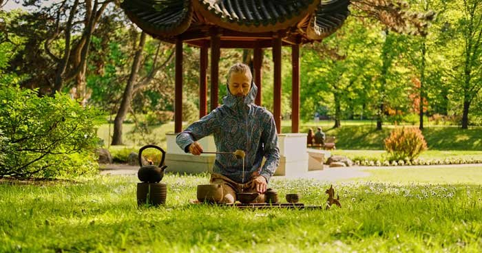 a person in modern clothing hosting a tea ceremony