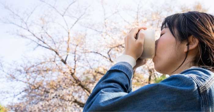 a woman drinking a bowl of matcha tea